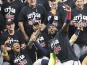 Atlanta Braves&#039; Marcell Ozuna, front, pretends to take a selfie as he celebrates with teammates after they defeated the Miami Marlins in Game 3 of a baseball National League Division Series, Thursday, Oct.