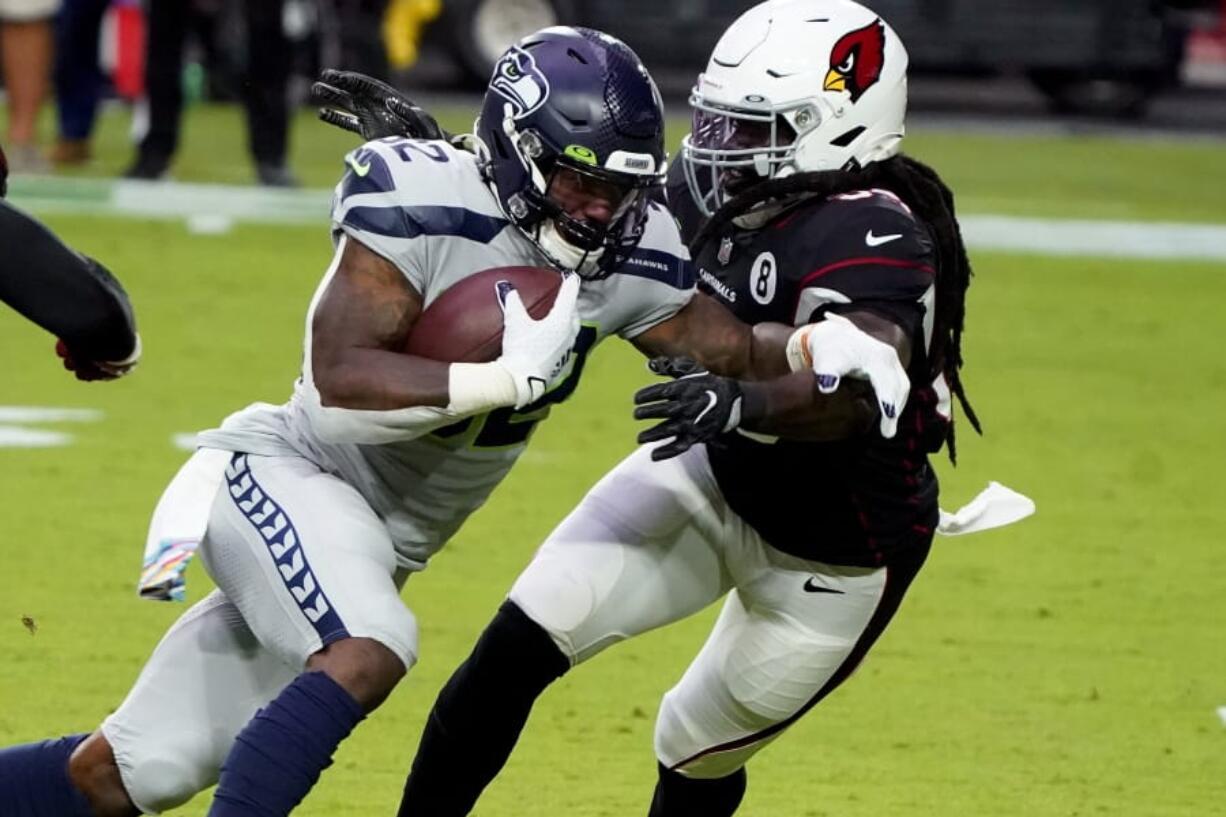 Seattle Seahawks running back Chris Carson (32) runs as Arizona Cardinals outside linebacker De&#039;Vondre Campbell defends during the first half of an NFL football game, Sunday, Oct. 25, 2020, in Glendale, Ariz.