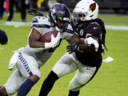 Seattle Seahawks running back Chris Carson (32) runs as Arizona Cardinals outside linebacker De&#039;Vondre Campbell defends during the first half of an NFL football game, Sunday, Oct. 25, 2020, in Glendale, Ariz.