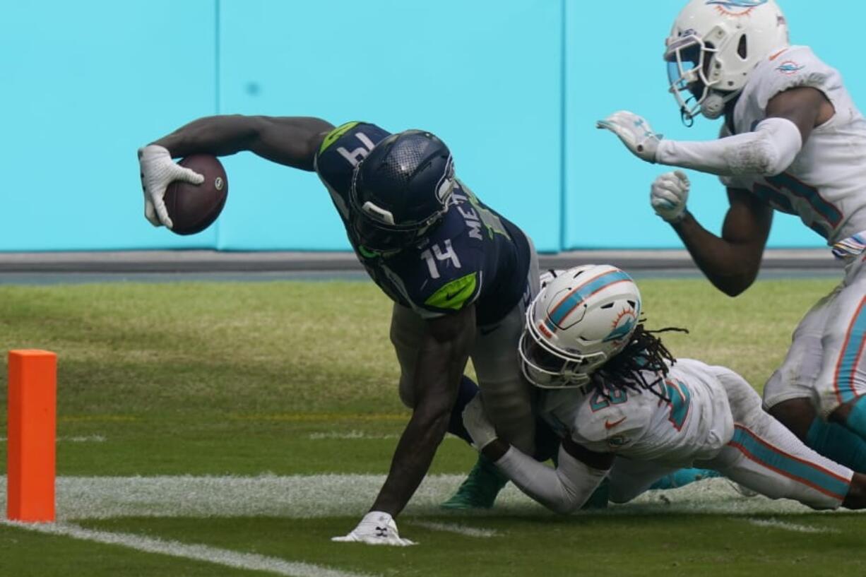 Miami Dolphins strong safety Bobby McCain (28) takes Seattle Seahawks wide receiver DK Metcalf (14) near the end zone, during the second half of an NFL football game, Sunday, Oct. 4, 2020, in Miami Gardens, Fla.