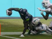 Miami Dolphins strong safety Bobby McCain (28) takes Seattle Seahawks wide receiver DK Metcalf (14) near the end zone, during the second half of an NFL football game, Sunday, Oct. 4, 2020, in Miami Gardens, Fla.