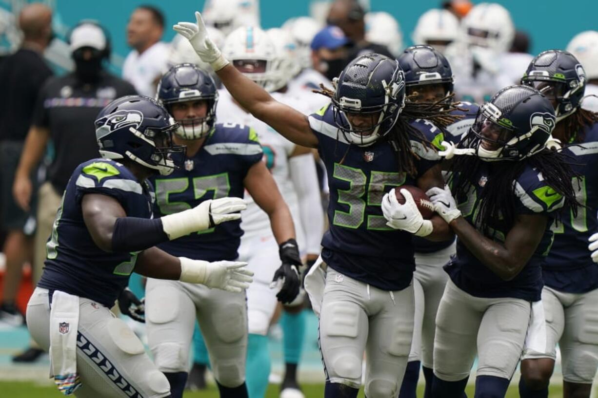 Seattle Seahawks cornerback Ryan Neal (35) is celebrated by his teammates after intercepting a pass, during the first half of an NFL football game against the Miami Dolphins, Sunday, Oct. 4, 2020 in Miami Gardens, Fla.