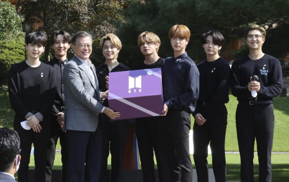 South Korean President Moon Jae-in, third from left, receives a gift from members of South Korean K-Pop group BTS during a ceremony marking the National Youth Day at the presidential Blue House in Seoul, South Korea, Saturday, Sept. 19, 2020.