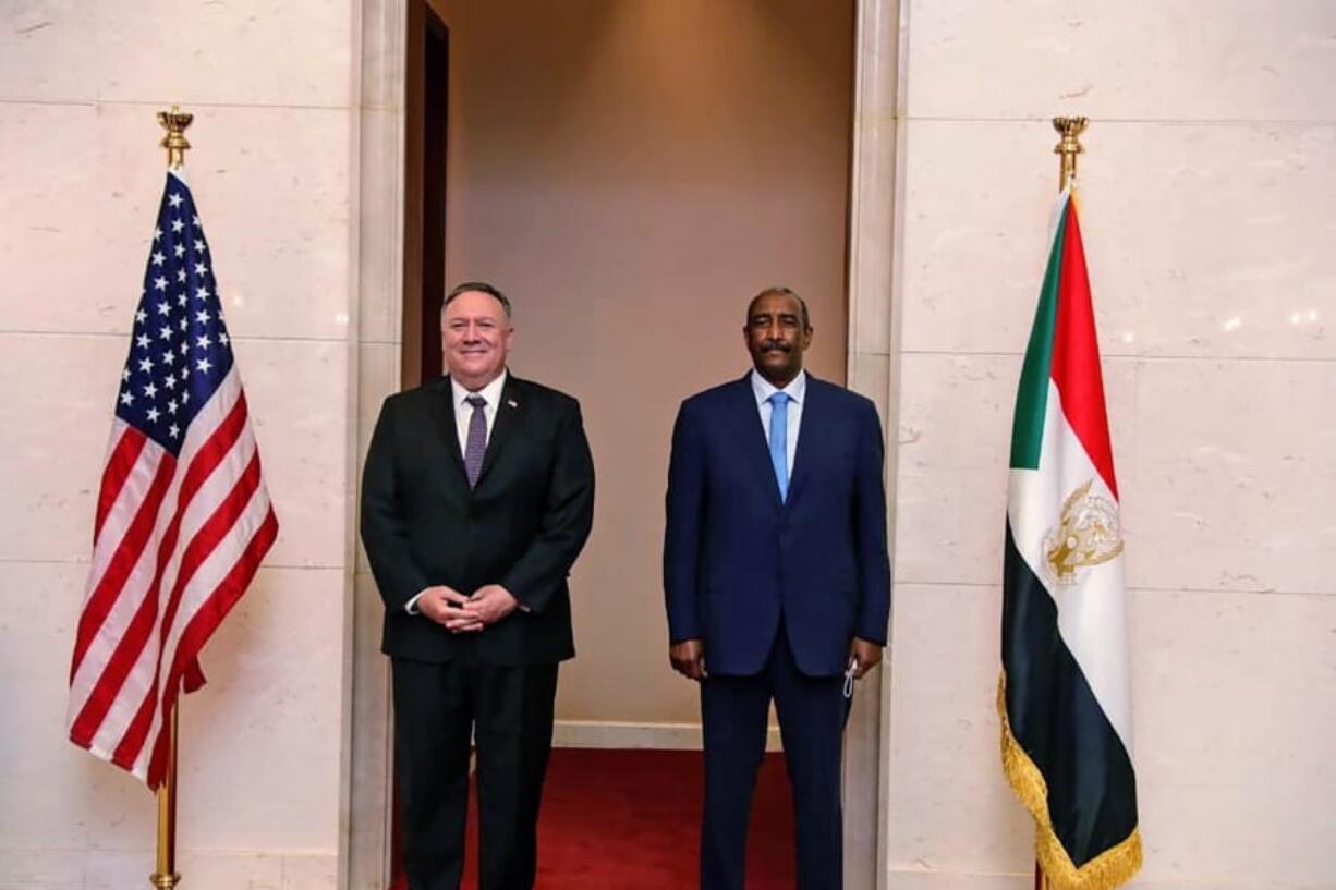 FILE - In this Aug. 25, 2020 file photo, U.S. Secretary of State Mike Pompeo stands with Sudanese Gen. Abdel-Fattah Burhan, the head of the ruling sovereign council, in Khartoum, Sudan. Officials in Sudan confirmed that a senior U.S.-Israeli delegation flew to Sudan on a private jet Wednesday, Oct. 21, 2020, and met with Burhan and others to wrap up a deal that would make Sudan the third Arab country to normalize ties with Israel this year.