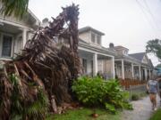 People walk along a sidewalk in New Orleans as the outer eye wall of Hurricane Zeta passed by the city, Wednesday, Oct. 28, 2020.