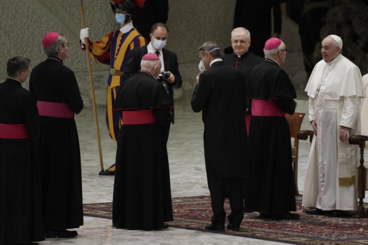 Pope Francis, right, greets bishops Wednesday at the end of his weekly general audience in the Paul VI hall at the Vatican.