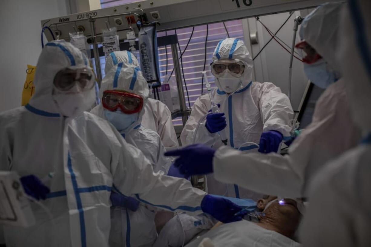 FILE - In this Oct. 9, 2020, file photo, a medical team treats a patient infected with COVID-19 in one of the intensive care units (ICU) at the Severo Ochoa hospital in Leganes, outskirts of Madrid, Spain. Europe&#039;s second wave of coronavirus infections has struck well before flu season even started. Intensive care wards are filling up again and bars are shutting down.