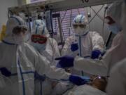 FILE - In this Oct. 9, 2020, file photo, a medical team treats a patient infected with COVID-19 in one of the intensive care units (ICU) at the Severo Ochoa hospital in Leganes, outskirts of Madrid, Spain. Europe&#039;s second wave of coronavirus infections has struck well before flu season even started. Intensive care wards are filling up again and bars are shutting down.