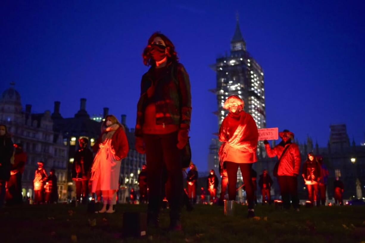 Demonstrators hold a silent vigil in Parliament Square to rise awareness on entertainment and arts world, in London, Saturday, Oct. 31, 2020. Backstage technicians and crews are calling for more fundingfrom the government for the performing arts and hospitality sectors as the coronavirus lockdown is widely anticipated to be extended in England to help control the spread of COVID-19.