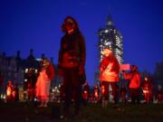 Demonstrators hold a silent vigil in Parliament Square to rise awareness on entertainment and arts world, in London, Saturday, Oct. 31, 2020. Backstage technicians and crews are calling for more fundingfrom the government for the performing arts and hospitality sectors as the coronavirus lockdown is widely anticipated to be extended in England to help control the spread of COVID-19.