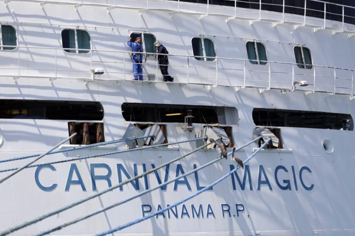 FILE - In this April 4, 2020 file photo, workers perform maintenance on the Carnival cruise line ship Carnival Magic while it is docked at Port Canaveral,  in Cape Canaveral, Fla.  Carnival Cruise Line is canceling most U.S. sailings through the end of this year. It&#039;s the latest sign that the cruise industry&#039;Aos recovery from the coronavirus pandemic could still be many months away. The company says it&#039;s canceling sailings from all ports except its home ports of Miami and Port Canaveral, Florida, but it stressed that it still might not sail from those ports in November and December.