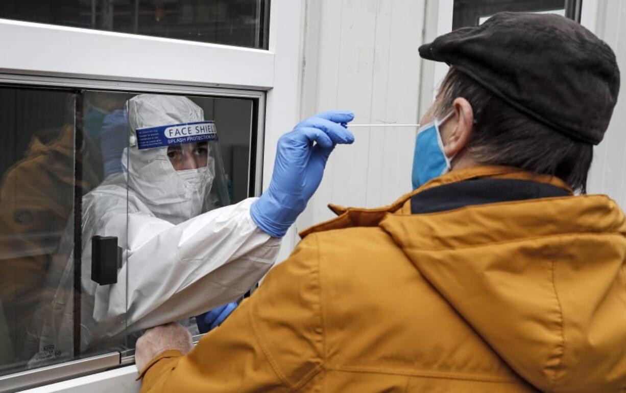 Medical staff takes a COVID-19 test at a coronavirus test center in Cologne, Germany, Thursday, Oct. 15, 2020. The city exceeded the important warning level of 50 new infections per 100,000 inhabitants in seven days. More and more German cities become official high risk corona hotspots with travel restrictions within Germany.