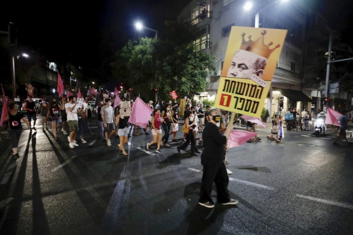 Israeli protesters march on the street during a demonstration against Israeli Prime Minister, Benjamin Netanyahu in Tel Aviv, Israel, Saturday, Oct. 10, 2020.