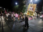 Israeli protesters march on the street during a demonstration against Israeli Prime Minister, Benjamin Netanyahu in Tel Aviv, Israel, Saturday, Oct. 10, 2020.