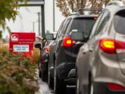 Drivers line up to drop off ballots at a Clark County ballot drop box Tuesday in the Vancouver Mall parking lot. A rush of voters arrived at the box, southeast of Macy&#039;s, shortly after noon Tuesday.