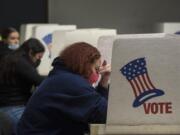 Vancouver resident Melissa Taylor keeps her concentration as she joins fellow residents while voting at the Clark County Elections Office on Tuesday afternoon, Nov. 3, 2020.