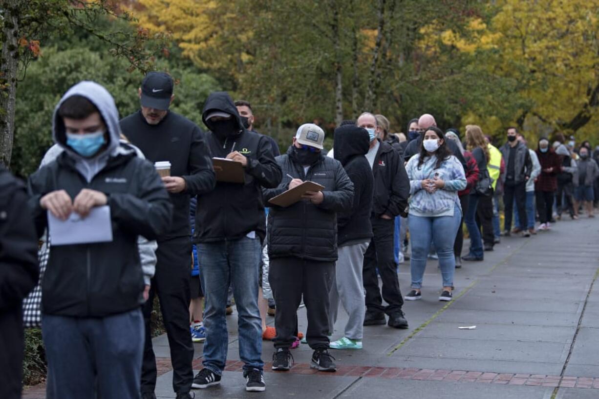 A long line stretches down Mill Plain Boulevard as voters wait to enter at the Clark County Elections Office in Vancouver on Tuesday afternoon.