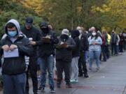 A long line stretches down Mill Plain Boulevard as voters wait to enter at the Clark County Elections Office in Vancouver on Tuesday afternoon.