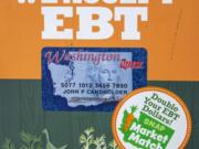 A sandwich board advertises the benefits of using an EBT card at the Vancouver Farmers Market.