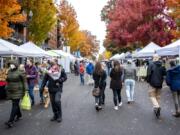 People survey vendors Saturday at the Vancouver Farmers Market in downtown Vancouver. The fall market continues every Saturday from 9 a.m. to 2 p.m. through Dec. 19. At top, Jackie Allen, left, surveys the produce at Sunnyside-based Bautista Farms&#039; market stall.