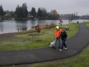 Matt and Fran Gray of La Center keep in step with their dog, Riley, during a lunchtime stroll Nov. 20 at Horseshoe Lake Park in Woodland. The lake is located in both Clark and Cowlitz counties. It used to be part of the Lewis River but was cut off from the waterway when Highway 99, now Interstate 5, was constructed.