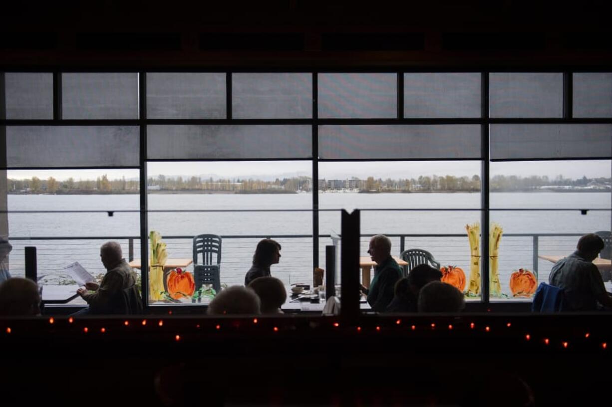 Decorations celebrating the season surround the indoor dining area at Beaches restaurant as customers get in one last lunch on Monday before COVID-19 restrictions on dining go back in place. Gov. Jay Inslee announced Sunday that restaurants would need to halt indoor seating for a month in response to a statewide spike in COVID-19 cases.