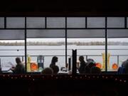 Decorations celebrating the season surround the indoor dining area at Beaches restaurant as customers get in one last lunch on Monday before COVID-19 restrictions on dining go back in place. Gov. Jay Inslee announced Sunday that restaurants would need to halt indoor seating for a month in response to a statewide spike in COVID-19 cases.