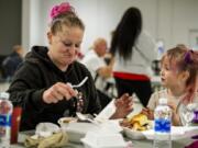 Ashley Green and her daughter, Jordiyn, 7, enjoy a Thanksgiving meal catered by Daddy D's BBQ on Saturday at Living Hope Church. Green has been coming to Living Hope for eight years, and the church provided services that helped Green get out of homelessness.