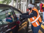 Sara Scheetz hands Thanksgiving dinners to a drive-thru visitor at WareHouse &#039;23 in Vancouver. The restaurant&#039;s annual Thanksgiving Day meal service was restructured this year for delivery and curbside service.