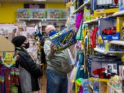 Christine Olsen, left, and Carl Olsen look for Christmas gifts for their kids on Saturday at Kazoodles toy store at Columbia Square in Vancouver. They went to Kazoodles to support small businesses.