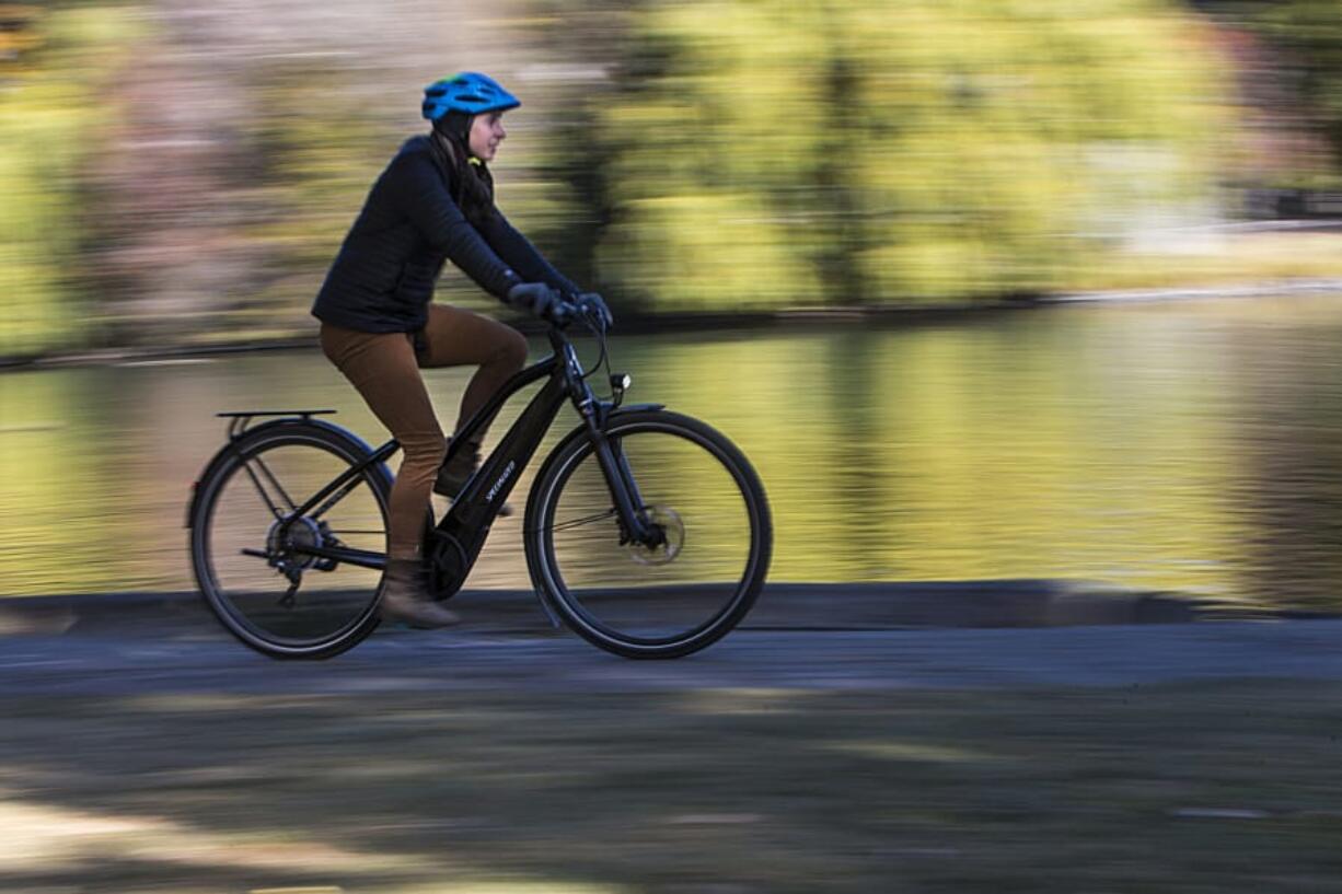 Emma Juth rides an electric bike through Drake Park in Bend, Ore.