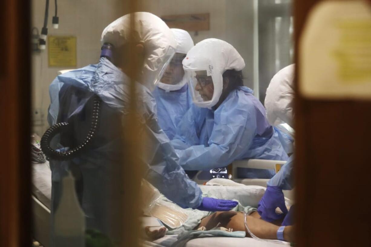 Respiratory therapist Neeru Kaur, right, and other medical staff work on a patient in May 8, 2020, in the COVID-19 Intensive Care Unit at Harborview Medical Center in Seattle, which is part of the health care system UW Medicine.