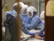 Respiratory therapist Neeru Kaur, right, and other medical staff work on a patient in May 8, 2020, in the COVID-19 Intensive Care Unit at Harborview Medical Center in Seattle, which is part of the health care system UW Medicine.