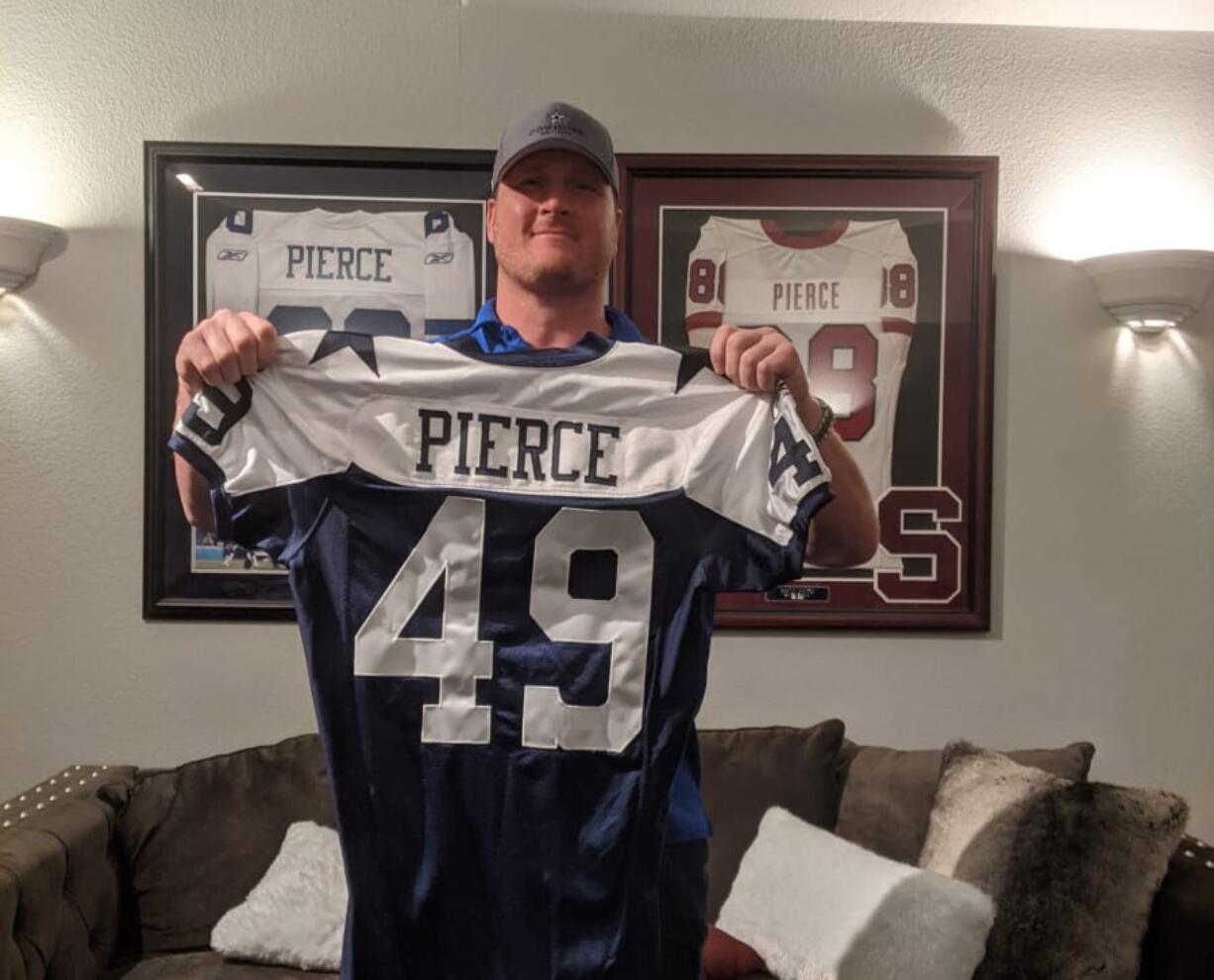 In his Dallas-area home, Brett Pierce holds his Dallas Cowboys jersey for the 2005 Thanksgiving Day game against the Denver Broncos.