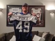 In his Dallas-area home, Brett Pierce holds his Dallas Cowboys jersey for the 2005 Thanksgiving Day game against the Denver Broncos.