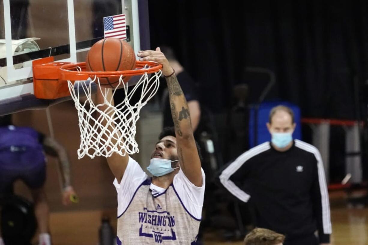 Washington forward J&#039;Raan Brooks dunks as coach Mike Hopkins watches during a recent practice in Seattle. Brooks, a transfer from USC, is one of only three players on the Huskies roster who is 6-foot-9 or taller.