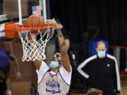 Washington forward J&#039;Raan Brooks dunks as coach Mike Hopkins watches during a recent practice in Seattle. Brooks, a transfer from USC, is one of only three players on the Huskies roster who is 6-foot-9 or taller.