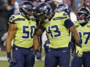 Seattle Seahawks outside linebacker K.J. Wright (50) and defensive end Carlos Dunlap (43) celebrate after a play against the Arizona Cardinals during the first half of an NFL football game, Thursday, Nov. 19, 2020, in Seattle.