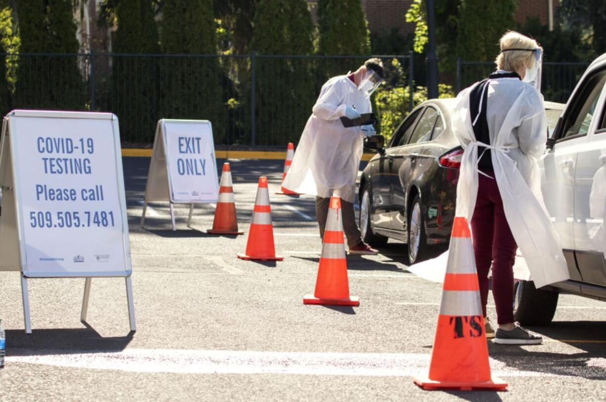 Faculty members from Washington State University Health Sciences Spokane administer COVID-19 tests to students at a mobile testing site in September during the coronavirus pandemic on campus in Pullman.