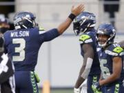 Seattle Seahawks quarterback Russell Wilson (3) celebrates with wide receiver DK Metcalf, center, after Wilson passed to Metcalf for a touchdown against the San Francisco 49ers during the first half of an NFL football game, Sunday, Nov. 1, 2020, in Seattle.