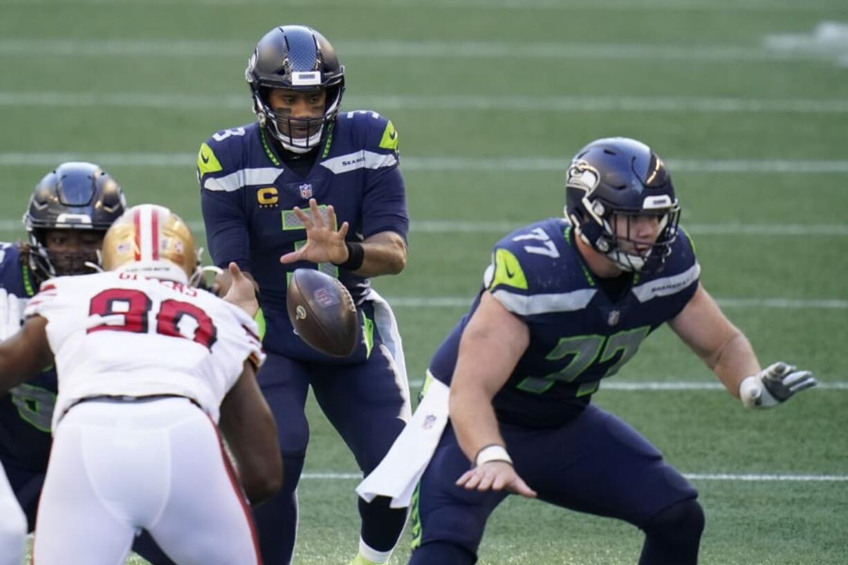 Seattle Seahawks quarterback Russell Wilson (3) takes a snap as center Ethan Pocic, right, blocks against the San Francisco 49ers during the first half of an NFL football game, Sunday, Nov. 1, 2020, in Seattle.