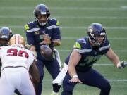 Seattle Seahawks quarterback Russell Wilson (3) takes a snap as center Ethan Pocic, right, blocks against the San Francisco 49ers during the first half of an NFL football game, Sunday, Nov. 1, 2020, in Seattle.