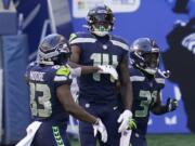 Seattle Seahawks wide receiver DK Metcalf (14) celebrates with teammates David Moore, left, and DeeJay Dallas, right, after Metcalf scored a touchdown against the San Francisco 49ers during the first half of an NFL football game, Sunday, Nov. 1, 2020, in Seattle.