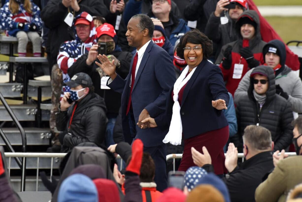 Housing and Urban Development Secretary Ben Carson, left, and his wife, Candy Carson, walk on stage at a campaign rally for President Donald Trump at Oakland County International Airport, Friday, Oct. 30, 2020, in Waterford Township, Mich.