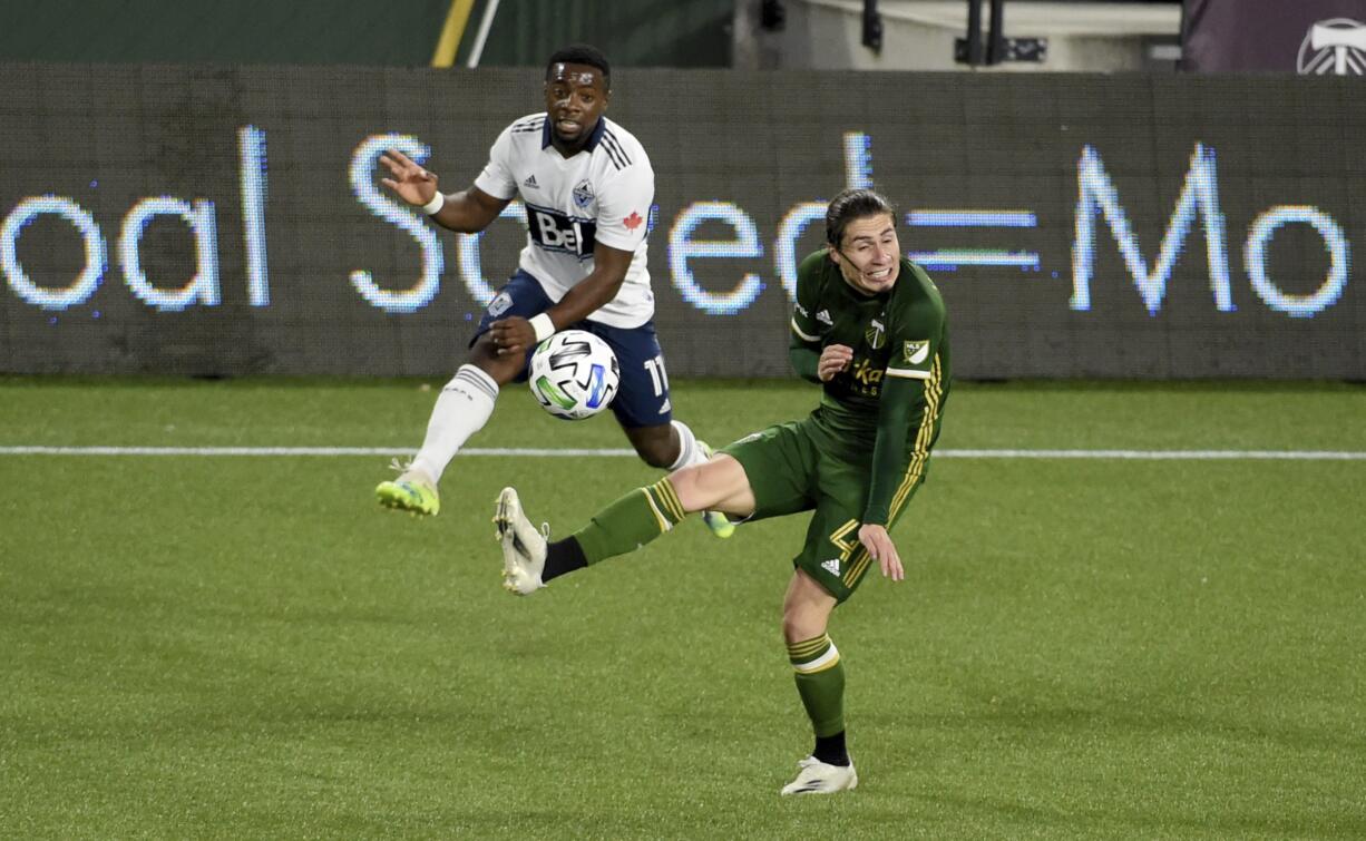 Vancouver Whitecaps forward Cristian Dajome, left, puts a shot on goal as Portland Timbers defender Jorge Villafana defends during the first half of an MLS soccer match in Portland, Ore., Sunday, Nov. 1, 2020.