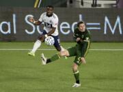 Vancouver Whitecaps forward Cristian Dajome, left, puts a shot on goal as Portland Timbers defender Jorge Villafana defends during the first half of an MLS soccer match in Portland, Ore., Sunday, Nov. 1, 2020.