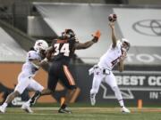 Washington State quarterback Jayden de Laura (4) throws past Oregon State inside linebacker Avery Roberts (34) and Washington State's Deon McIntosh (3) during the first half of an NCAA college football game in Corvallis, Ore., Saturday, Nov, 7, 2020.