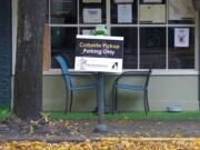 A sign for curbside pickup is shown outside the Cascadia Grill, Sunday, Nov. 15, 2020, in downtown Olympia. (AP Photo/Ted S.