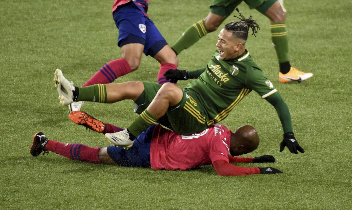 FC Dallas forward Fafa Picault, bottom, slide tackles Portland Timbers defender Pablo Bonilla, top, during the first half of an MLS soccer match in Portland, Ore., Sunday, Nov. 22, 2020.