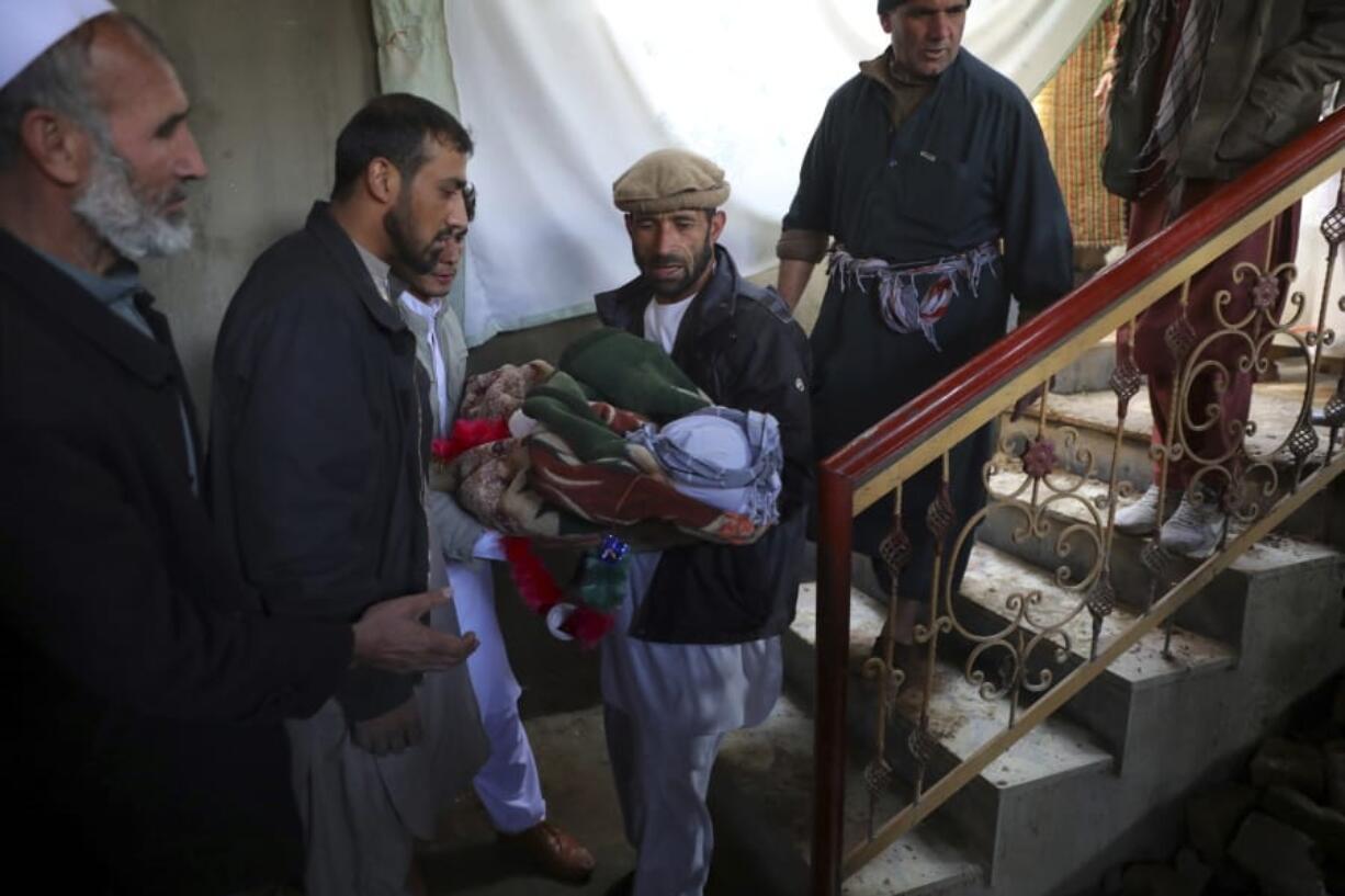 Relatives carry the dead body of a boy who was killed by a mortar shell attack in Kabul, Afghanistan, Saturday, Nov. 21, 2020. Mortar shells slammed into different parts of the Afghan capital on Saturday.